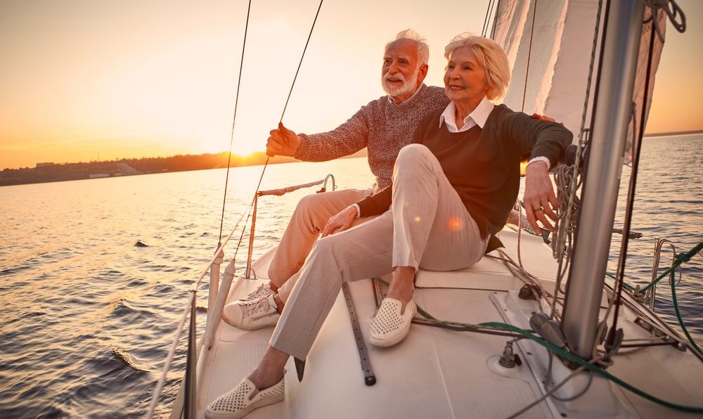 Couple on sailing yacht, sunset behind them