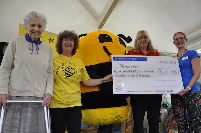 Attending the cheque presentation at Colten Care's Woodpeckers care home in Brockenhurst are l-r: resident Betty Hampton; Viv Carter, Honeypot’s Regional Community Fundraising Officer with mascot Bumble; Woodpeckers Companionship Team Member Anita Roberts and Home Manager Katie Whiteside.