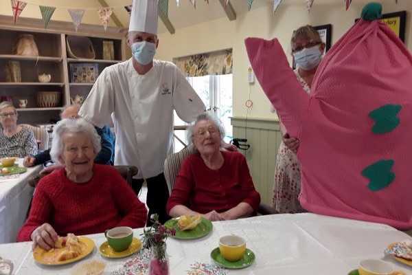chef with two ladies and tea cosy