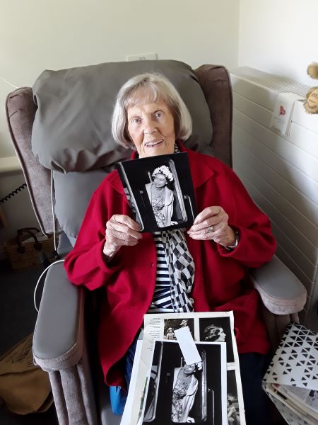 Belmore Lodge resident and former royal milliner Louisa McIntyre with a picture of the Queen wearing a hat she made.