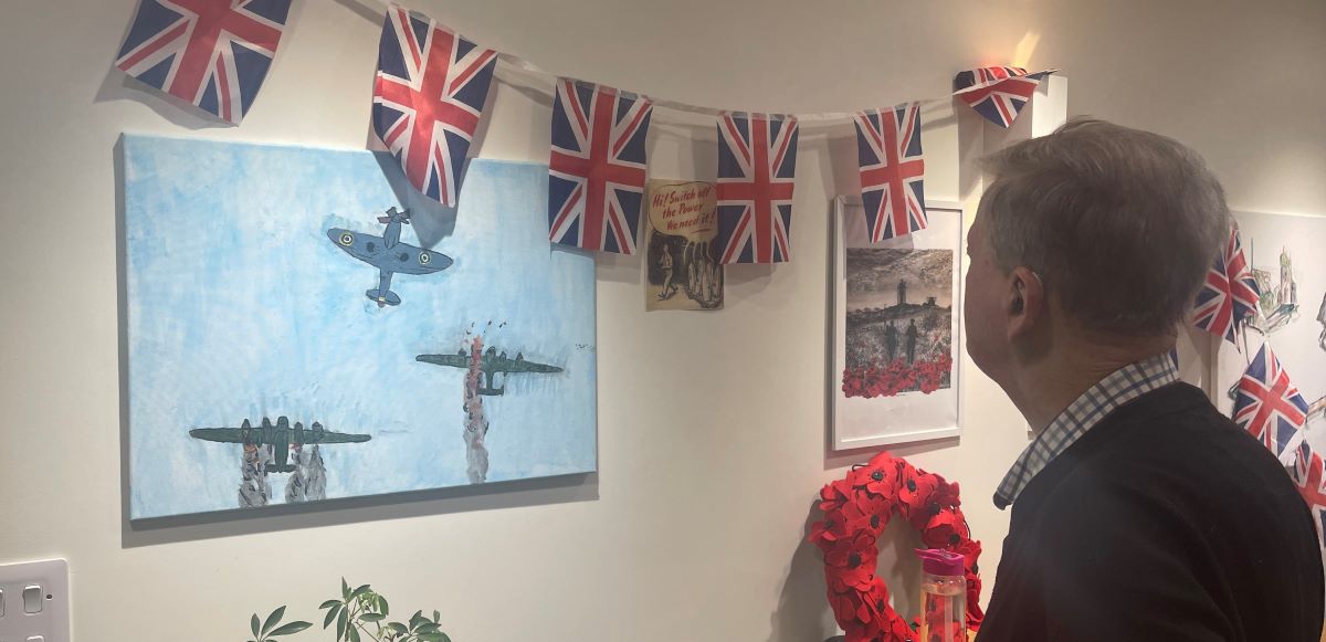 Resident at Colten Care hom looking at pictures created for Remembrance
